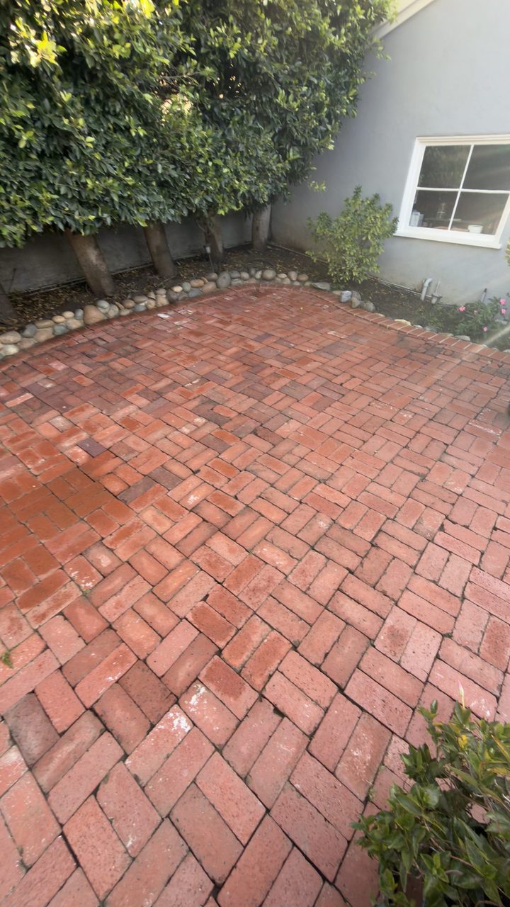 Brick paver patio after pressure washing, bright and even red brick